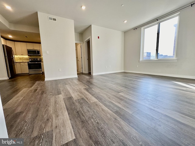 unfurnished living room with dark wood-style floors, baseboards, visible vents, and recessed lighting