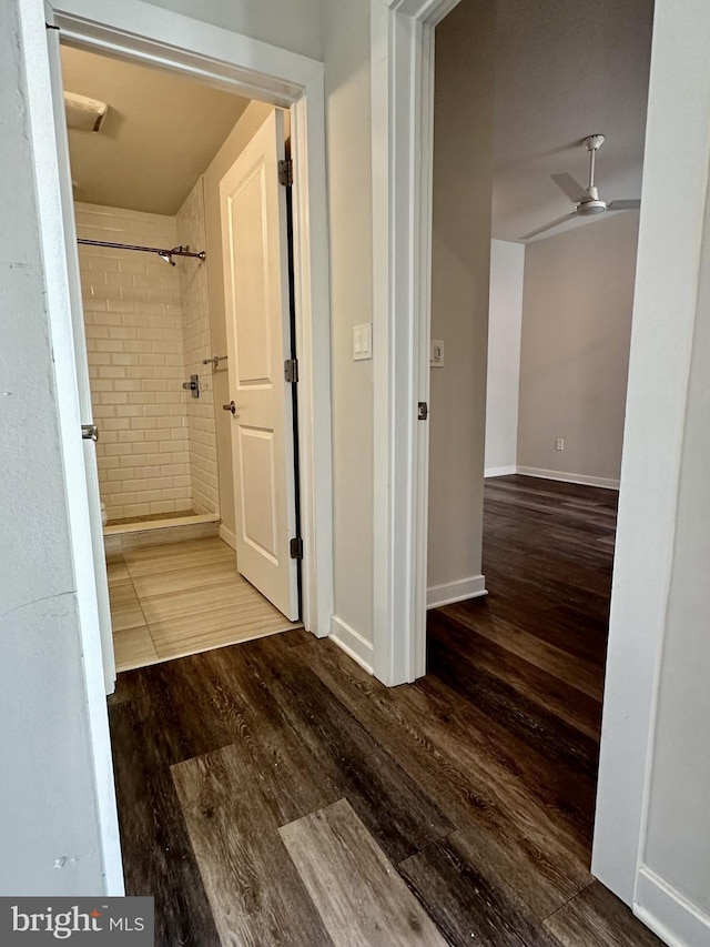 corridor featuring baseboards and wood finished floors