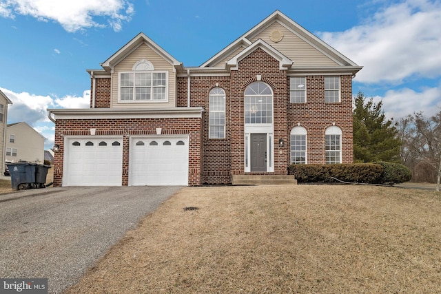 view of front of house with a garage, brick siding, driveway, and a front lawn