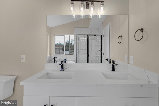 bathroom featuring double vanity, a shower stall, a sink, and lofted ceiling