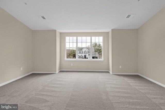 empty room with light carpet, visible vents, and baseboards