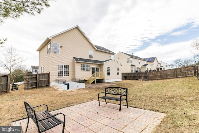 back of property featuring a yard, a patio, and fence