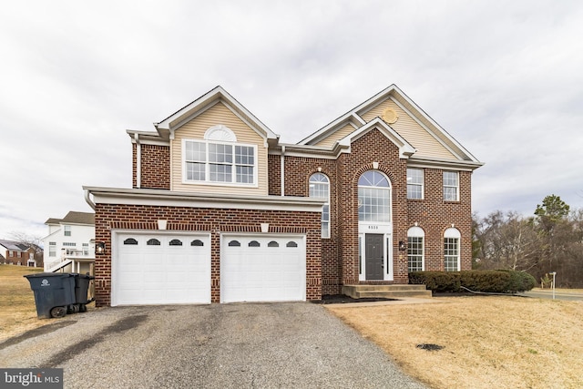 view of front of property featuring aphalt driveway, brick siding, an attached garage, and a front lawn