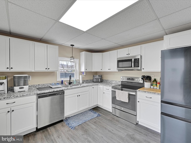 kitchen featuring appliances with stainless steel finishes, white cabinets, and a sink