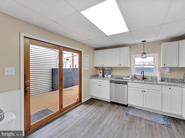 kitchen featuring hanging light fixtures, white cabinetry, and dishwasher