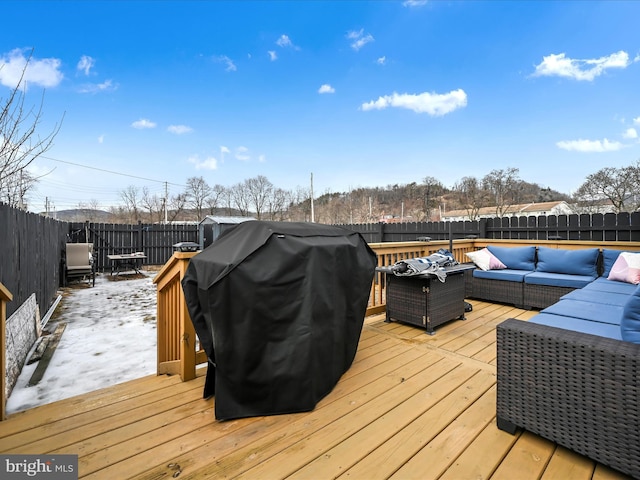 deck with an outdoor hangout area, grilling area, and a fenced backyard