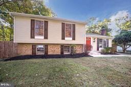 split level home with fence and a front yard