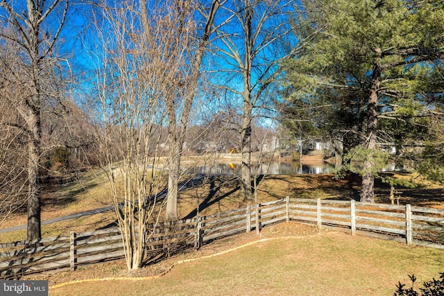 view of yard featuring a water view and fence