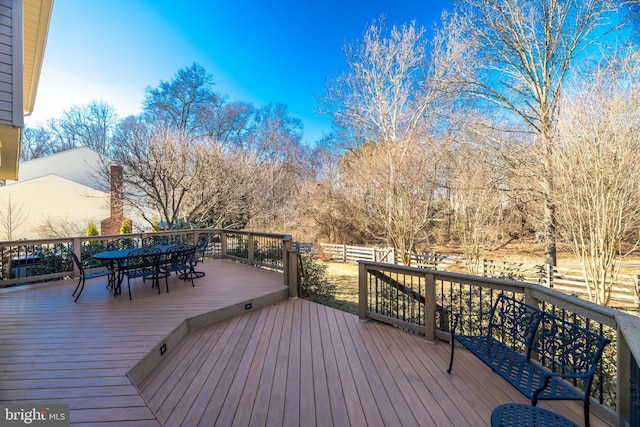 wooden terrace with fence and outdoor dining space