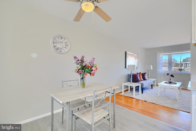 dining space featuring ceiling fan, light wood-style flooring, and baseboards