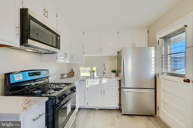 kitchen with white cabinetry, appliances with stainless steel finishes, and light countertops