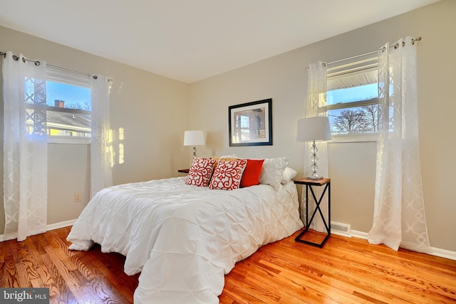 bedroom featuring multiple windows, wood finished floors, and visible vents