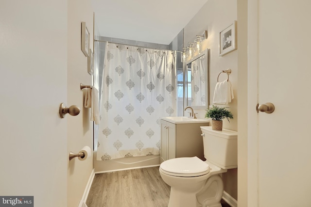 full bathroom with toilet, wood finished floors, vanity, baseboards, and shower / bath combo