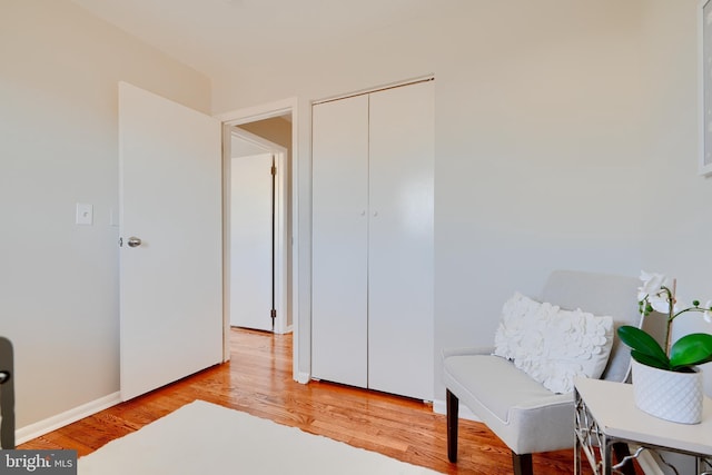 living area with light wood-type flooring and baseboards