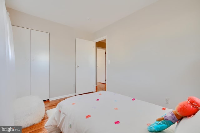 bedroom featuring light wood finished floors and a closet