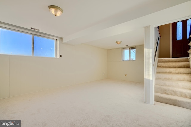 basement featuring carpet floors, stairs, and visible vents