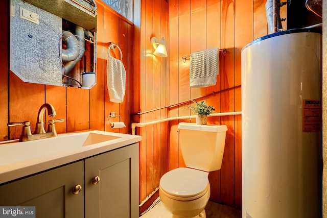 bathroom featuring water heater, vanity, toilet, and wooden walls