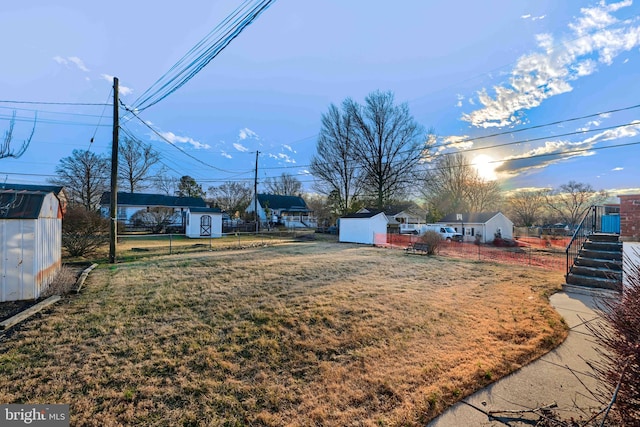 view of yard with an outdoor structure, a storage shed, and fence