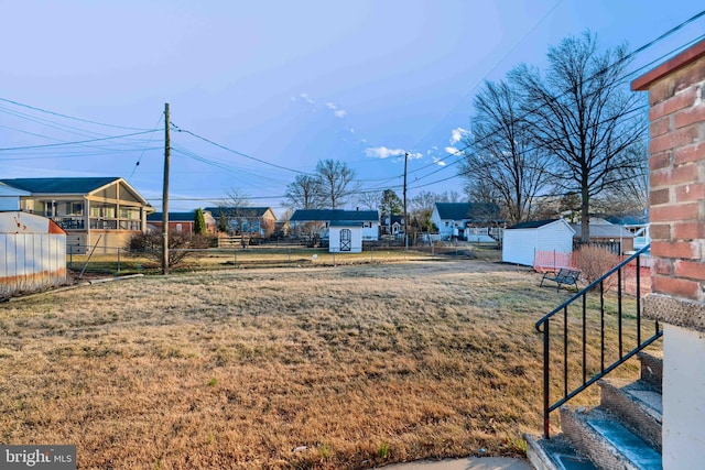 view of yard featuring a storage unit, fence, and an outbuilding