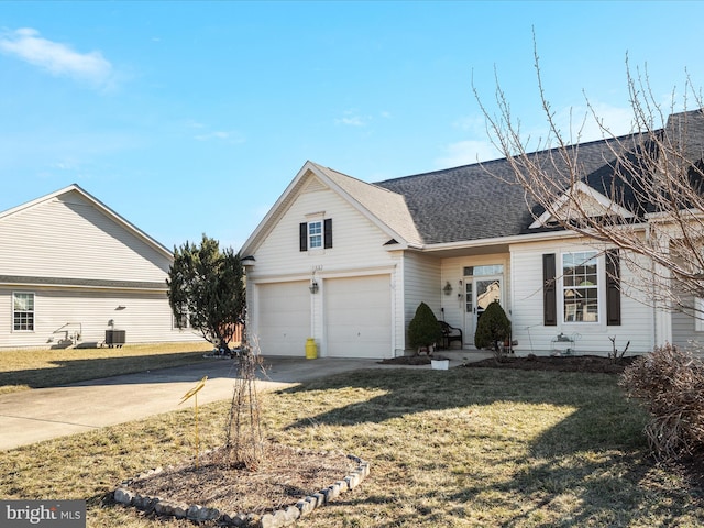 view of front of property with a garage, concrete driveway, roof with shingles, and a front yard