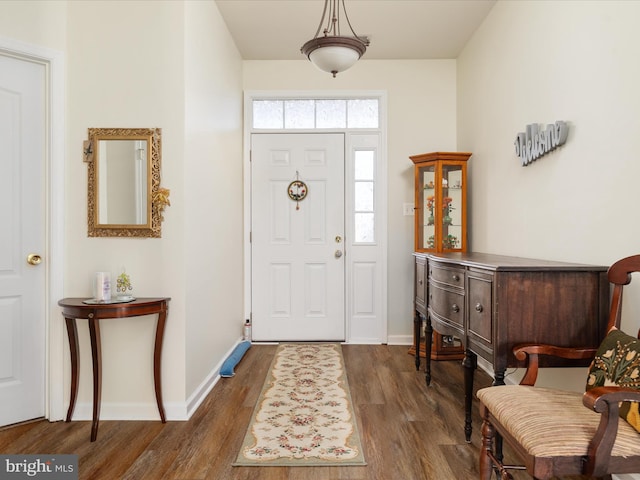 entrance foyer with dark wood finished floors and baseboards