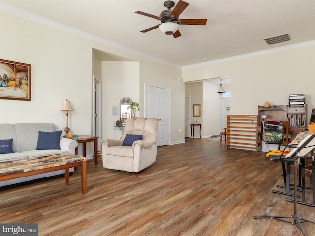 living area featuring ornamental molding, visible vents, and wood finished floors