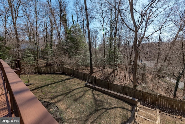 view of yard featuring a view of trees and a fenced backyard