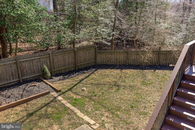 view of yard with a fenced backyard and stairs