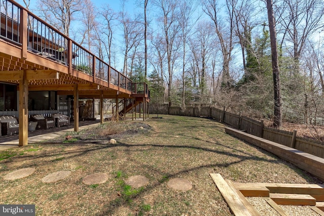 view of yard with a wooden deck, a patio, a fenced backyard, and stairs