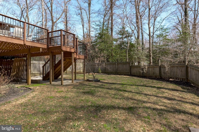 view of yard featuring a deck, stairway, and a fenced backyard