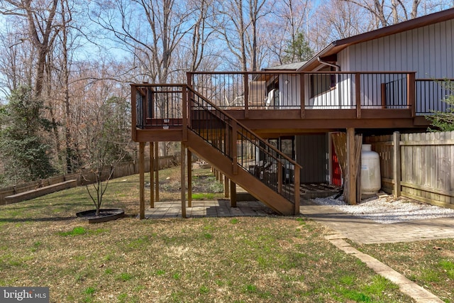 exterior space featuring stairway, a lawn, a wooden deck, and fence