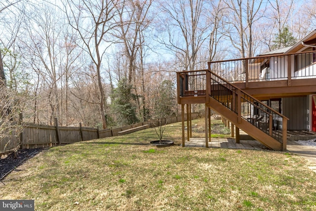 view of yard with stairway, a wooden deck, and a fenced backyard