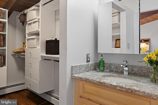 bathroom featuring vanity, a baseboard heating unit, and wood finished floors