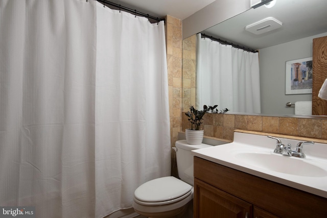 bathroom featuring tile walls, visible vents, toilet, and vanity