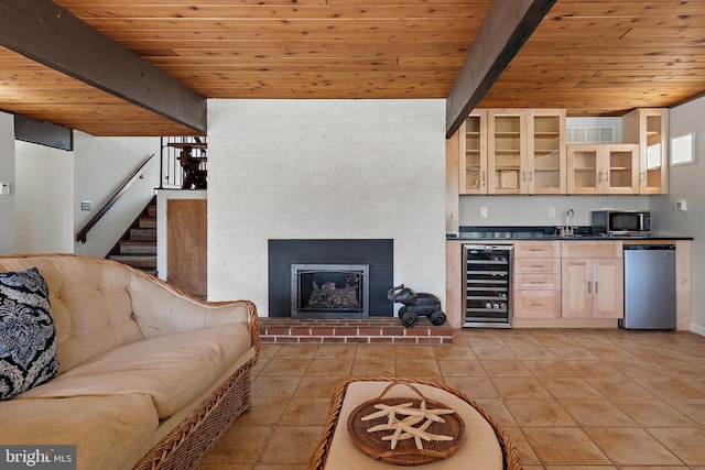 living area featuring stairway, wine cooler, beam ceiling, and wooden ceiling