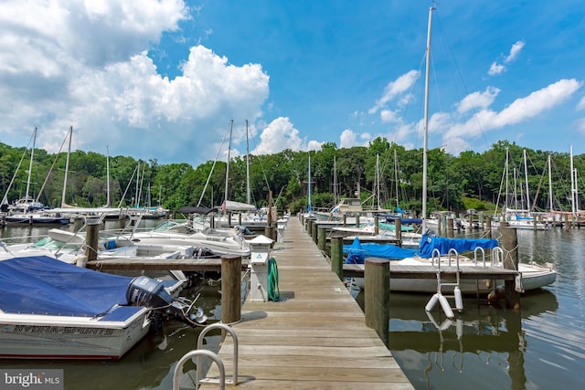 dock area featuring a water view and a wooded view