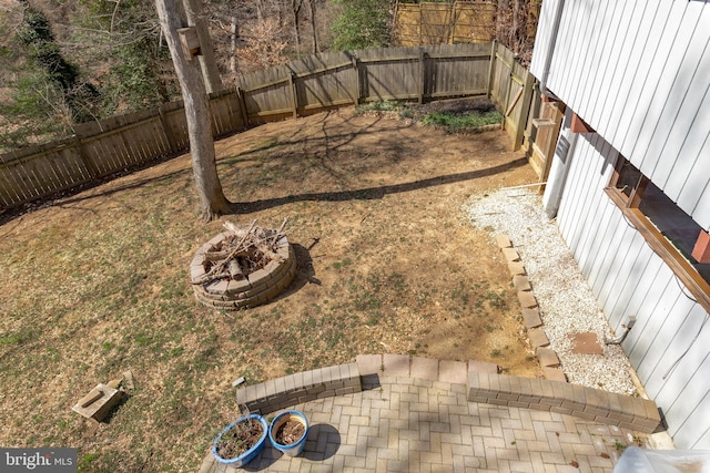 view of yard with a fenced backyard and an outdoor fire pit