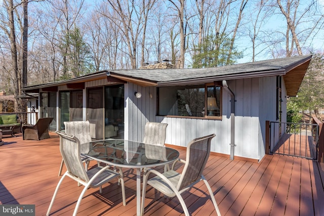 deck with outdoor dining space and a sunroom