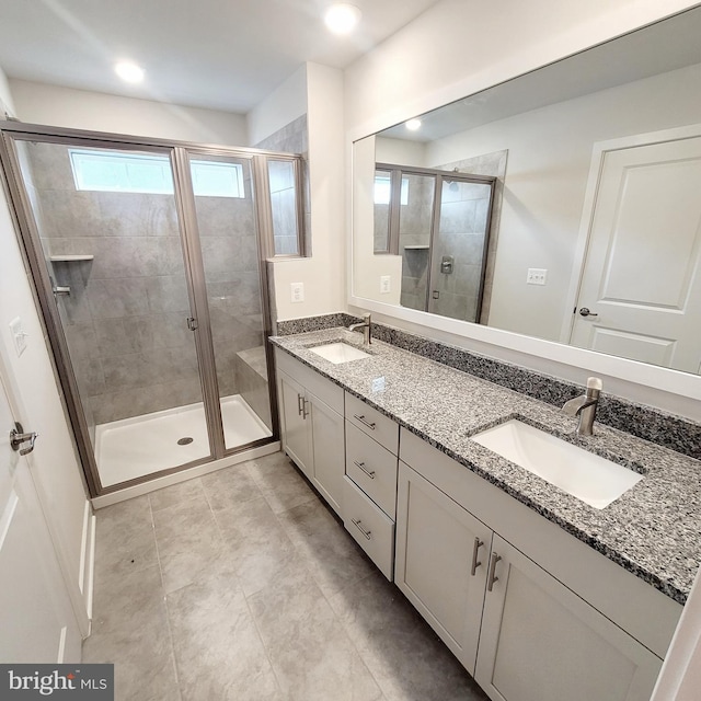 bathroom with double vanity, a stall shower, a sink, and recessed lighting