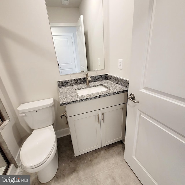 bathroom featuring tile patterned flooring, vanity, and toilet