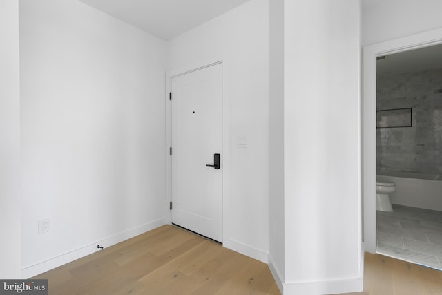 hallway featuring light wood-style floors and baseboards