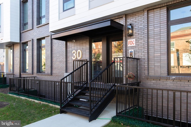 view of exterior entry with brick siding