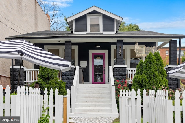 bungalow featuring covered porch and a fenced front yard