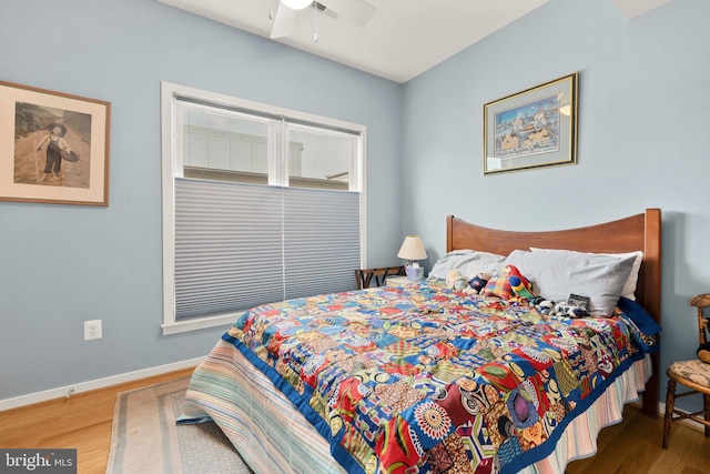 bedroom featuring ceiling fan, baseboards, and wood finished floors