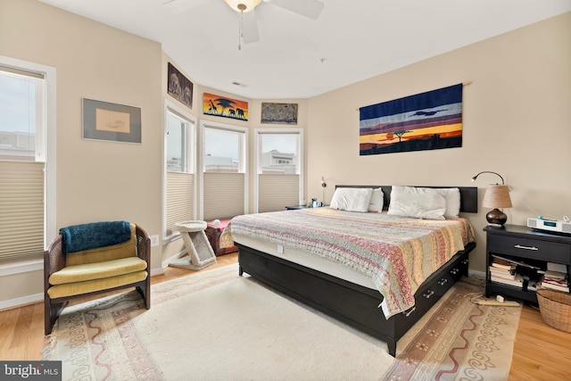 bedroom with ceiling fan, wood finished floors, and baseboards