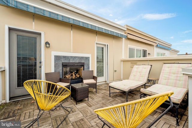 wooden deck featuring a patio and an outdoor living space with a fireplace