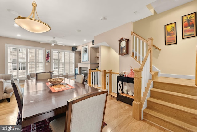 dining space with stairway, recessed lighting, light wood-style flooring, and baseboards