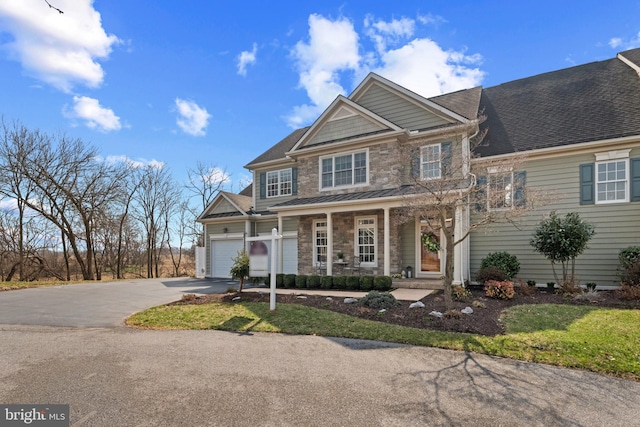 view of front of house featuring aphalt driveway, stone siding, a porch, and a shingled roof