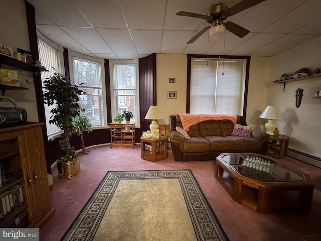 living room with ceiling fan, carpet flooring, and a paneled ceiling