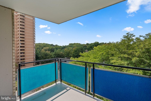 balcony featuring a forest view